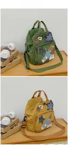 Detailansicht der Retro-Canvas-Taschen in Armeegrün und Gelb mit Vintage-Patch-Verzierung