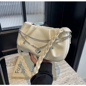 Détail du sac nuage plissé crème avec chaînes en métal argenté et pendentif en cœur