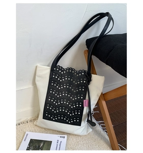 Detail of canvas tote bag with black laser-cut lace pattern and pink Fashion label