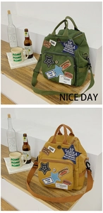 Detailansicht eines Vintage-Canvas-Rucksacks mit Stickpatches und mehreren Reißverschlüssen