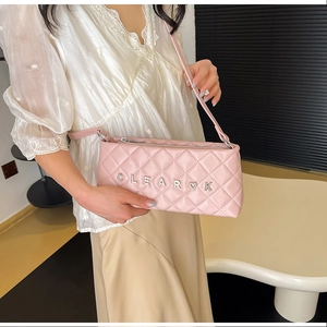 Detail of pink quilted crossbody bag featuring metal CLEAR K heart letters and fine strap