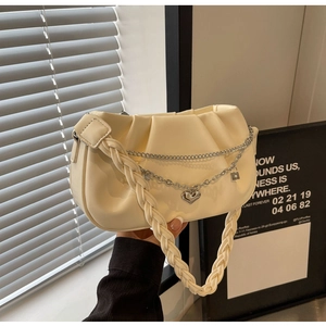 Détail du sac nuage plissé blanc crème avec poignée tressée et chaîne argentée à cœur