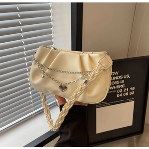 Détail du sac nuage plissé blanc cassé avec poignée tissée et chaîne argentée à pendentif cœur