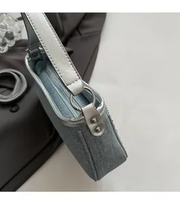Dettaglio della borsa blu argento con finiture metalliche e tessuto con trama in denim