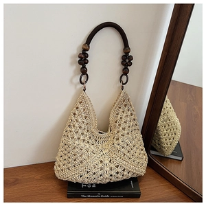 Detailed close-up of handmade beige woven straw bag with dark brown polished wooden bead handle