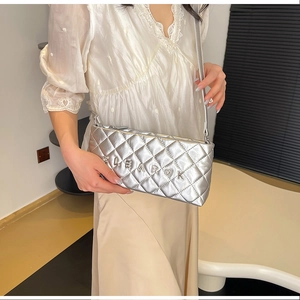 Detail of silver quilted crossbody bag with metal LEAROK logo and chain strap