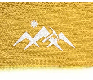 Macro detail of yellow ripstop fabric with white mountain logo on a hiking backpack