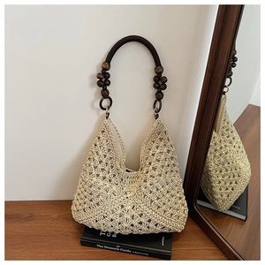 Detail view of hollow crochet woven tote bag featuring unique dark brown wooden bead handles
