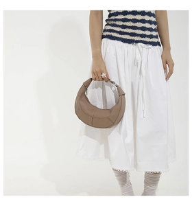 Close-up of vertical stitching detail on a brown leather hobo bag for women