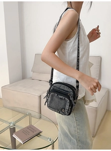 Vue détaillée d'un sac bandoulière vintage en denim noir avec plusieurs fermetures éclair