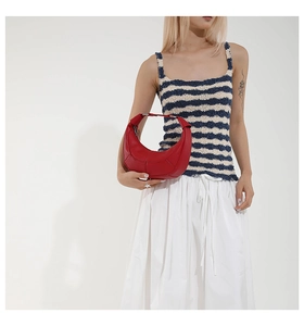 Detail of red leather hobo bag with tonal stitching and sleek crescent moon shape