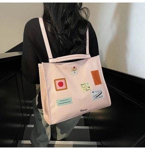 Detail of pink large tote bag with cute embroidery patches and wide shoulder strap