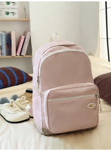 Close-up of light pink backpack with durable zipper pocket and soft woven handle