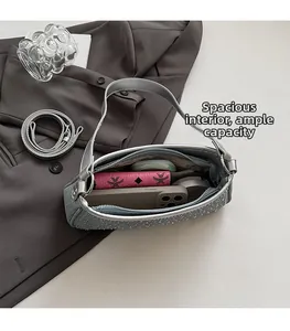 Dettaglio dell'ampio scomparto interno di questa borsa a tracolla in denim con strass