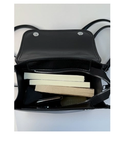 Internal view of the black leather backpack showing ample storage for books and phone