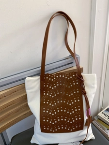 Fashionable contrast color tote bag with laser-cut brown leather detail and star charm