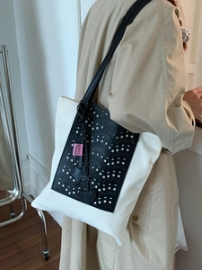 Contrast color canvas tote bag with laser-cut leather detail and star charms on model