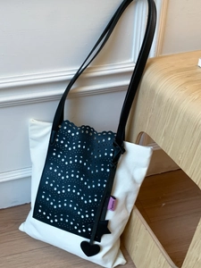 Fashionable black and white contrast canvas tote bag with laser-cut hollow wave pattern