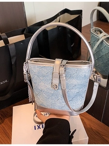 Borsa a secchiello in denim blu con manico argento e chiusura a girello moda