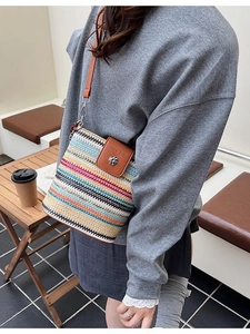 Sac seau en paille tressée à rayures avec bandoulière en cuir brun et boucle en métal