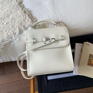 Close-up of cream white leather backpack featuring silver buckles and smooth PU texture