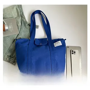 Detail view of large navy blue canvas tote bag showcasing spacious compartments and pockets