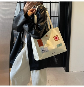 Detail of white tote bag with animal patches and embroidery for daily commuting