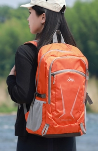 Detail of 40L waterproof orange hiking backpack showing mesh side pockets and strap quality