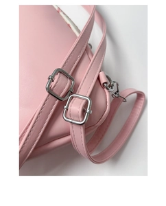 Detail of pink leather backpack strap featuring polished silver adjustment buckle