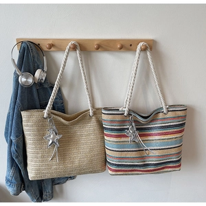 Detail of woven straw tote bags with thick cotton rope handles and silver star charms