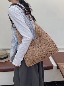 Handmade woven straw tote bag with unique brown wooden bead shoulder strap for summer