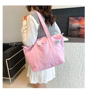 Side view of pink canvas tote bag with side pocket and fashion woven label for women