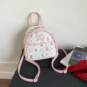 Detail of pink floral mini backpack with cute patterns and adjustable straps on soft seat