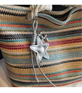 Detail of colorful striped woven tote with star and balloon dog metallic charms