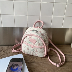 Detail of pink quilted mini backpack featuring cute teddy bear and bow patterns