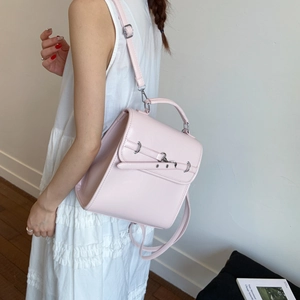 Detail of light pink glossy PU leather backpack with decorative silver ring and strap