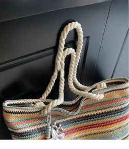 Detail of colorful rainbow woven tote bag with nautical rope handles and star charm