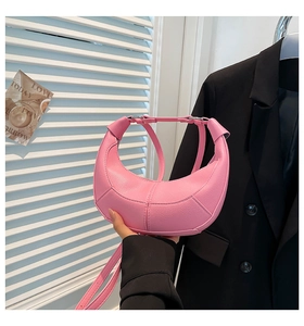 Detail of pink lychee leather dumpling bag showing texture and crescent shape