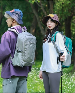 Close-up of 22L lightweight hiking backpacks with trekking poles in outdoor forest setting