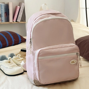 Pink waterproof nylon backpack with grey base and dual front pockets for travel or school
