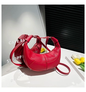 Macro detail of red crescent moon bag with litchi grain leather texture and silver rings