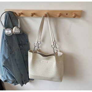 Détail du cabas en tricot crème avec texture tissée et bandoulière chaîne argentée
