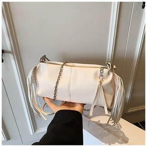 Detail of a creamy white pleated chain bag featuring long fringe tassels and a metal strap