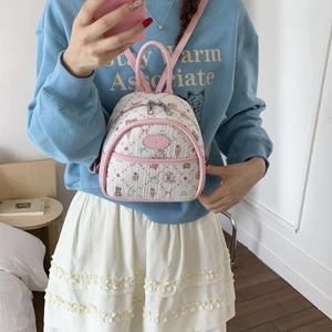 Mini backpack featuring white woven texture with pink teddy bear and floral pattern details