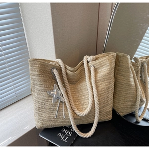 Close-up of beige woven tote bag showing rafia texture and cotton rope handles