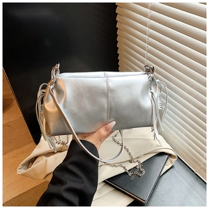 Detail of silver metallic handbag featuring long side fringes and mixed chain strap