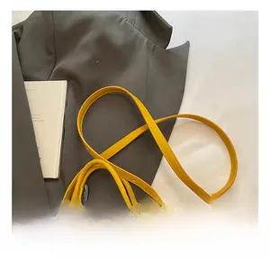 Detail of a bright yellow PU leather mini handbag with an adjustable shoulder strap