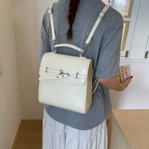 Side view of cream-white leather backpack featuring adjustable straps and polished buckle