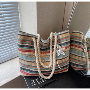 Detailed view of rainbow striped woven tote bag with cotton rope handles and star charm