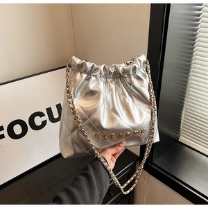 Detail of silver quilted leather bag featuring gold CLEAROK logo and chain strap